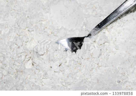 Close up of white flour in a bowl with a silver spoon 133978858