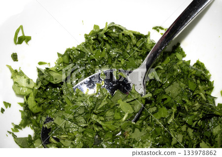 Close up of chopped coriander and parsley herbs on a white background 133978862