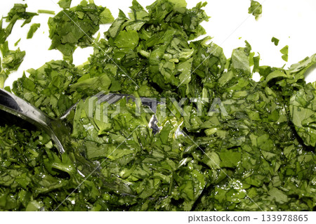 Close up of chopped coriander and parsley herbs on a white background 133978865