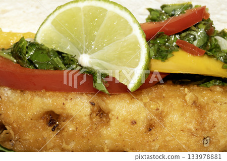 A very tasty fried pineapple taco with peppers and lime street food fresh meal 133978881