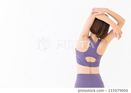 Middle-aged woman in yoga wear doing exercises 133979008