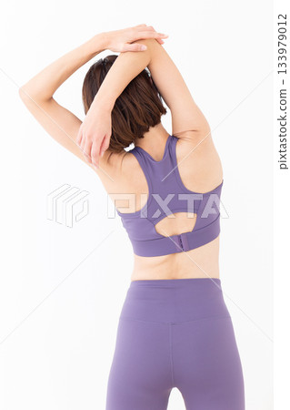 Middle-aged woman in yoga wear doing exercises 133979012