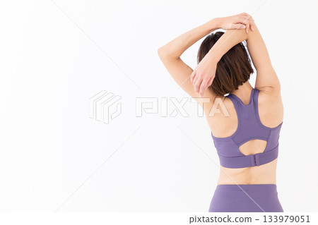 Middle-aged woman in yoga wear doing exercises 133979051