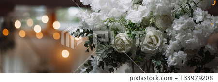 Banner white floral wedding arrangement on metal stand with blurred lights in background Banner white floral wedding arrangement on metal stand with blurred lights in background 133979208