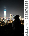 A woman and the Taipei 101 night view. A beautiful travel portrait with the glittering city as a backdrop. 133979836