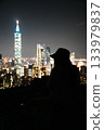 A woman and the Taipei 101 night view. A beautiful travel portrait with the glittering city as a backdrop. 133979837
