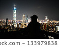 A woman and the Taipei 101 night view. A beautiful travel portrait with the glittering city as a backdrop. 133979838