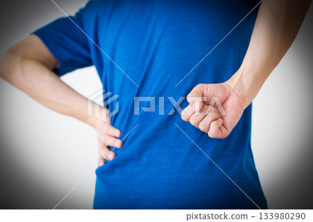一位身穿T恤的中年男子，背痛難耐。 133980290