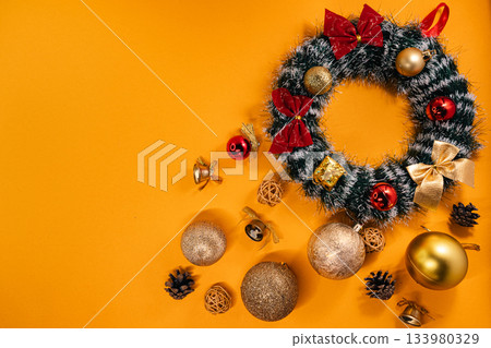 Holiday decoration featuring a Christmas wreath with ornaments and bows 133980329
