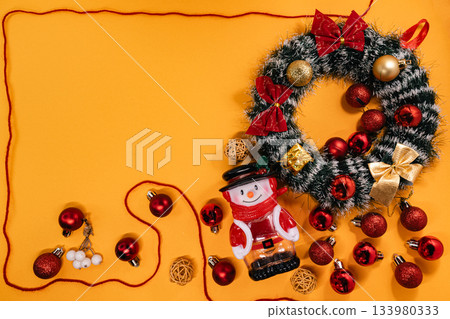 Cheerful Christmas arrangement featuring a wreath, snowman 133980333