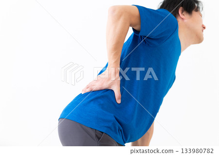 一位身穿T恤的中年男子，背痛難耐。 133980782