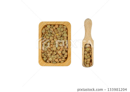 Green lentils in wooden bowl on isolated white background. Top view, copy space. Flat lay. Green lentils in wooden bowl on isolated white background. Top view, copy space. Flat lay. 133981204