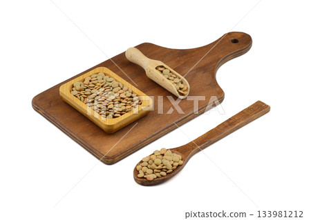Green lentils in wooden bowl on isolated white background. Top view, copy space. Flat lay. Green lentils in wooden bowl on isolated white background. Top view, copy space. Flat lay. 133981212