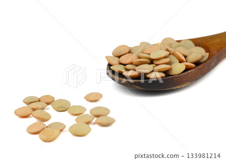 Pile lentil in wooden spoon isolated on White background. Top view. 133981214