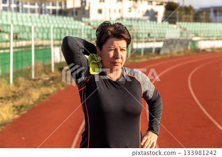 Woman wiping sweat after intense running Woman wiping sweat after intense running 133981242