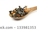 A pile of dry green tea on a white background. Apple flavor. Top view, isolated, close-up. Extreme close-up on the spoon. 133981353
