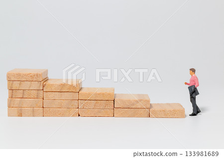 Businessman Climbing Wooden Steps Toward Success Businessman Climbing Wooden Steps Toward Success 133981689