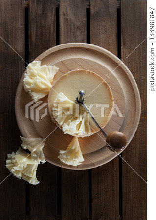 Tete des Moines cheese or "monk's head". Swiss tete des Moines cheese is sliced with a special zhirol knife. A knife for cutting zhirol cheese. 133981847