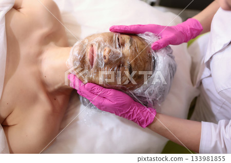 LED phototherapy for face. Preparation for photodynamic therapy. Young woman is undergoing facial treatment.Top view. 133981855