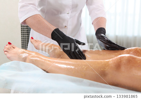 Scrub the skin of the feet before the procedures. Lymphatic drainage foot massage. Spa body treatments at the beauty salon. The concept of body care at the spa. 133981865