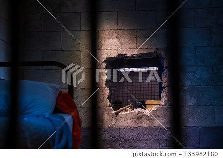 Prison break by wrecking wall by hammer. Escape and flee concept 133982180