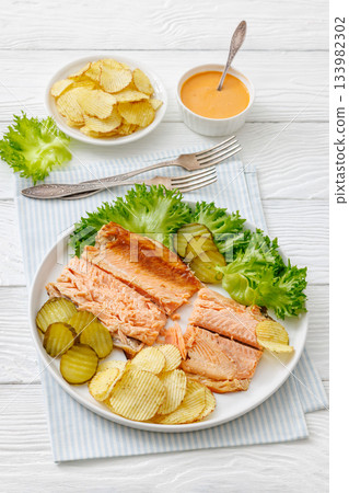 hot smoked trout fillet with lettuce, potato chips hot smoked trout fillet with lettuce, potato chips 133982302
