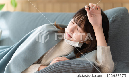 一名女子因身體不適躺在沙發上。 133982375