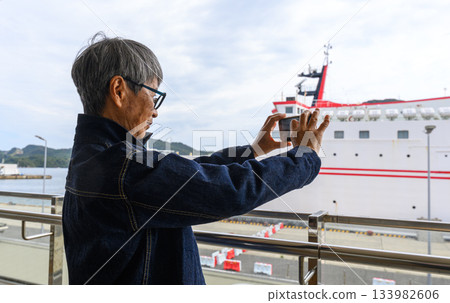 Elderly woman taking a photo on a ferry Elderly woman taking a photo on a ferry 133982606
