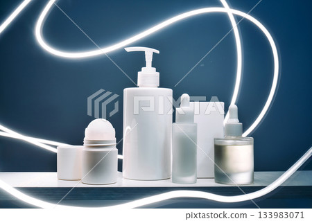 White cosmetic bottles and serum droppers on shelf 133983071