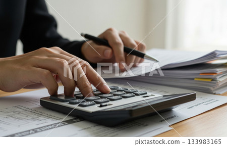 Accountant Calculating Finances with Documents 133983165