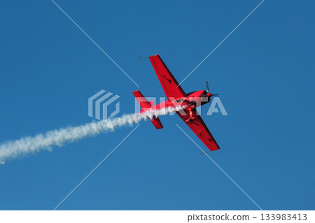 Stunt aerobatic plane performing stunts in air 133983413