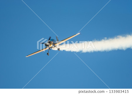 Stunt aerobatic plane performing stunts in air 133983415