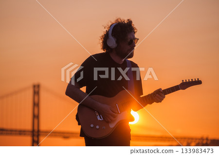 Street musician playing electric guitar in the street 133983473