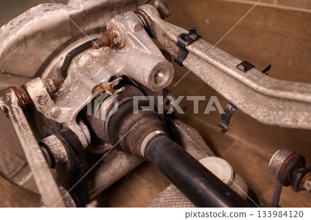 Vintage vehicle restoration, Old car parts under warm workshop lighting, Scene depicting classic vehicle undergoing restoration with rusted parts and scattered tools 133984120