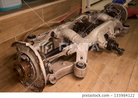 Vintage vehicle restoration, Old car parts under warm workshop lighting, Scene depicting classic vehicle undergoing restoration with rusted parts and scattered tools 133984122