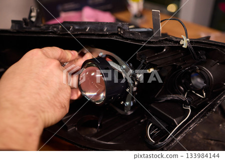Careful precision is essential when installing a car headlight assembly for optimal performance 133984144