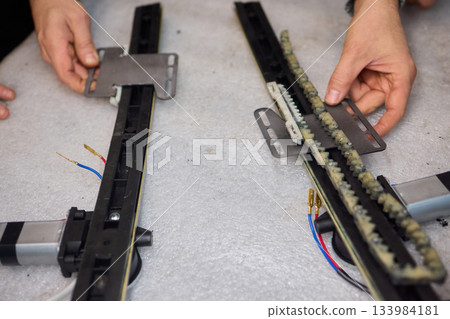 Focused technician conducts precise motor repairs, Dedicated technician methodically finetunes small motor assembly with specialized tools in workshop environment 133984181