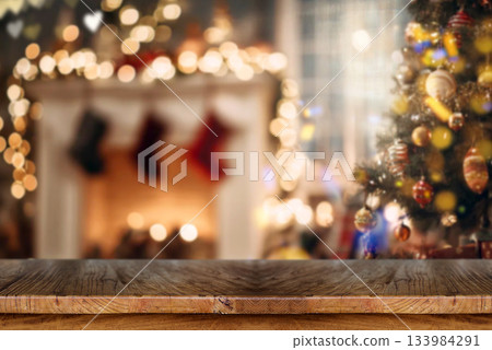 Wooden table with blurred Christmas tree and fireplace background Wooden table with blurred Christmas tree and fireplace background 133984291