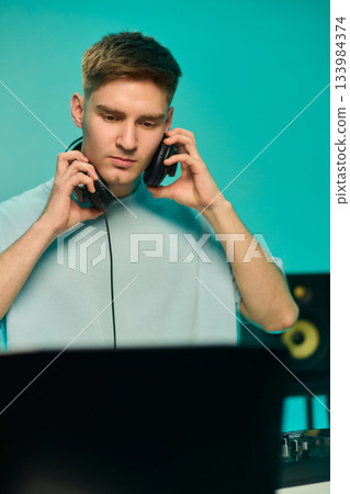 Youthful technician editing sound, Youthful sound engineer meticulously adjusting mixing console within modern streaming design setting to create perfect audio balance Youthful technician editing sound, Youthful sound engineer meticulously adjusting mixing console within modern streaming design setting to create perfect audio balance 133984374