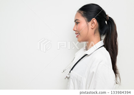 Profile View of Happy Woman Doctor with Stethoscope in White Uniform on Plain Background Smiling Profile View of Happy Woman Doctor with Stethoscope in White Uniform on Plain Background Smiling 133984394