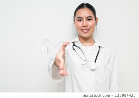 Happy Woman Doctor with Stethoscope in White Uniform on Plain Background Greeting with Handshake 133984425