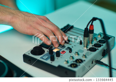 Closeup of tactile controls and vibrant patch cords in studio, Adjusting analog sequencing equipment with bright cables and warm ambient lighting in home studio Closeup of tactile controls and vibrant patch cords in studio, Adjusting analog sequencing equipment with bright cables and warm ambient lighting in home studio 133984445