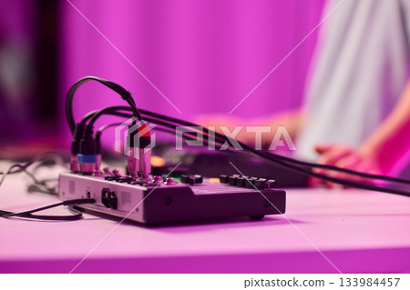 Closeup of tactile controls and vibrant patch cords in studio, Adjusting analog sequencing equipment with bright cables and warm ambient lighting in home studio Closeup of tactile controls and vibrant patch cords in studio, Adjusting analog sequencing equipment with bright cables and warm ambient lighting in home studio 133984457