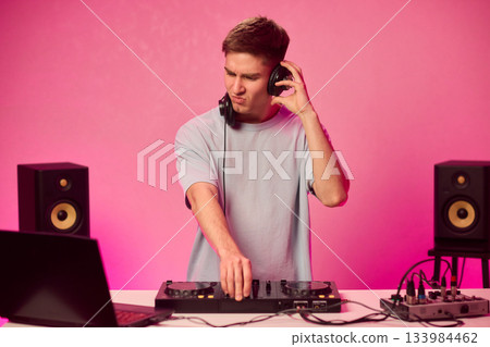 Youthful technician editing sound, Youthful sound engineer meticulously adjusting mixing console within modern streaming design setting to create perfect audio balance 133984462
