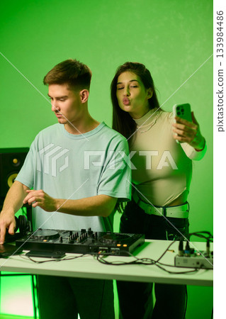 Music creators in studio, Studio session featuring musical synthesis and focused teamwork, Electronic music producers working together with various tools and instruments 133984486