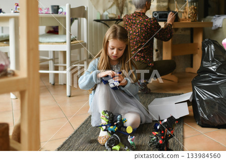 A girl unwraps the christmas presents 133984560