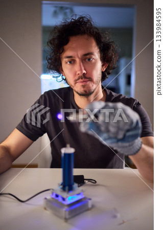 Hands test plasma, Detailed image of electrical discharge testing process, Precision testing of purple plasma arc by technician wearing gloves with detailed equipment Hands test plasma, Detailed image of electrical discharge testing process, Precision testing of purple plasma arc by technician wearing gloves with detailed equipment 133984595