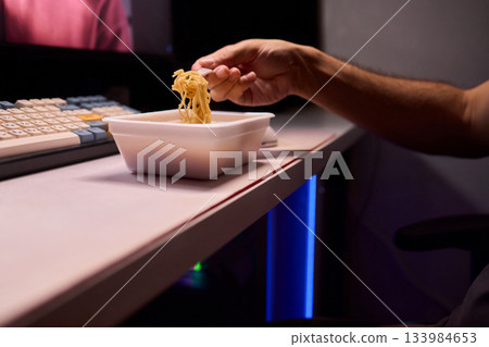 Live streaming snack, Content creator enjoys snack during livestream break, Casual moment captured during evening stream with ambient glow and home studio background Live streaming snack, Content creator enjoys snack during livestream break, Casual moment captured during evening stream with ambient glow and home studio background 133984653