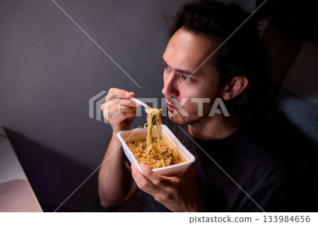 Live streaming snack, Content creator enjoys snack during livestream break, Casual moment captured during evening stream with ambient glow and home studio background Live streaming snack, Content creator enjoys snack during livestream break, Casual moment captured during evening stream with ambient glow and home studio background 133984656