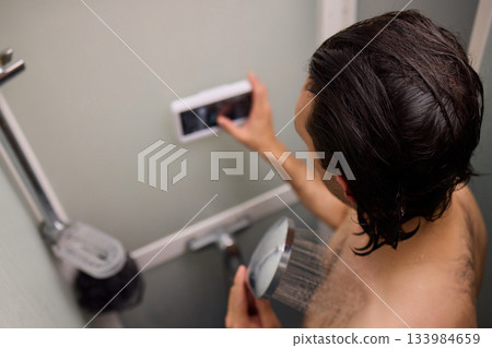 Nighttime routine of watching shows during shower time, Casual nighttime shower scene featuring someone watching shows on their phone amidst steamy bathroom atmosphere Nighttime routine of watching shows during shower time, Casual nighttime shower scene featuring someone watching shows on their phone amidst steamy bathroom atmosphere 133984659